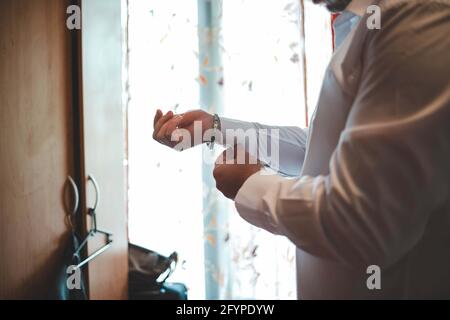 Bräutigam bereitet sich vor und legt ein formelles Outfit für den Hochzeitstag an Stockfoto
