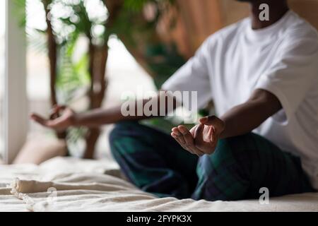Junger afrikanischer Mann meditiert an seinem Schlafzimmer in der sitzend Morgen Stockfoto
