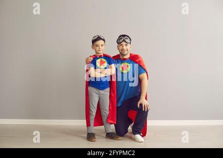 Vater und Sohn tragen ein Superhelden-Kostüm und blicken auf die Kamera studio-Porträt Stockfoto