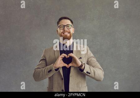 Erwachsener kaukasischer Geschäftsmann, der Herz mit Händen macht, die Liebe zeigen signieren Stockfoto
