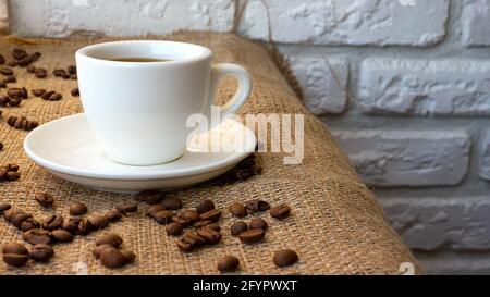 Duftender schwarzer Kaffee in einer Tasse, Kaffeebohnen mit einer Retro-Kaffeetasse. Stockfoto