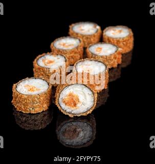 Tiefgebratene Sushi-Rollen mit Lachs und Philadelphia-Frischkäse. Hot Crispy Tempura Set mit auf schwarzem Hintergrund mit Copyspace Stockfoto