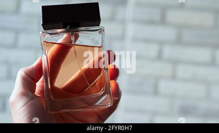 Das Parfüm des Mannes in der Hand eines Mannes. Glas für Spirituosen Kopierraum. Stockfoto