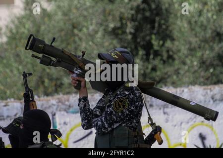 29. Mai 2021: Gaza, Palästina. 29 Mai 2021. Maskierte Kämpfer der Al-Quds-Brigaden, dem bewaffneten Flügel der Bewegung des Islamischen Dschihad in Palästina, ziehen in Gaza-Stadt mit verschiedenen militärischen Geräten, darunter Raketen, um. Die Parade war Teil eines öffentlichen Festivals mit dem Titel „das Schwert Jerusalems – das Versprechen kam näher“, an dem eine große Menge die Kämpfer auf den Saraya-Platz jubelte. Die Parade fand 8 Tage nach der Vereinbarung eines Waffenstillstands zwischen Israel und den palästinensischen Gruppen im Gazastreifen statt, wodurch 11 Tage Raketenbeschuss aus Gaza und aus Israel beendet wurden Stockfoto