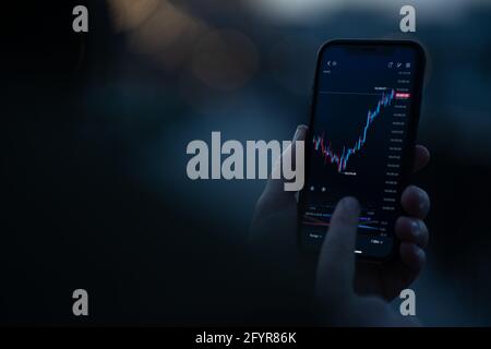 Anleger überprüfen Börsenmarktdaten in der mobilen App auf Smartphone Stockfoto