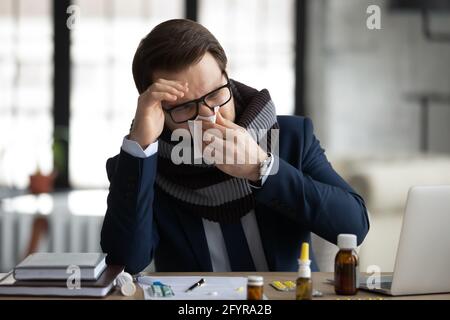 Traurige kranke Büroangestellte, Geschäftsmann, Manager in warmen Schal gewickelt Stockfoto