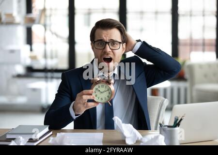 Panik verzweifelter Manager verpasst Termin, hält Wecker Stockfoto