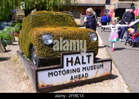 Schild und Mini-Auto mit Laub bedeckt im Cotswold Motoring Museum, Bourton-on-the-Water, Gloucestershire, England, Großbritannien, Vereinigtes Königreich. Stockfoto