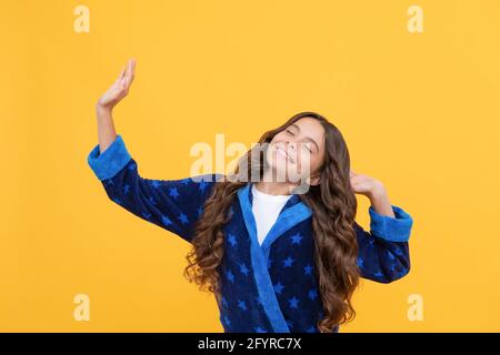 Happy teen Mädchen mit lockigen Haaren Stretching in komfortablen Pyjama, guten Morgen Stockfoto