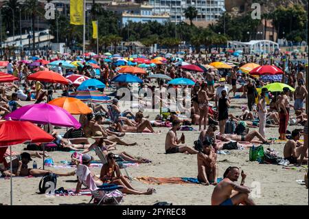 Alicante, Spanien. Mai 2021. Die Menschen genießen hohe Temperaturen in einem überfüllten El Postiguet Strand von Alicante. Die valencianische Gemeinschaft hat am Montag neue Beschränkungsmaßnahmen gegen das Coronavirus (Covid-19) veröffentlicht, unter anderem gegen das Coronavirus, An den Stränden ist es nicht mehr notwendig, in den Ruhezeiten vor oder nach dem Baden eine Maske zu tragen und dabei den Mindestabstand von 1.5 Metern zu anderen Menschen, die nicht zusammen leben, mit einer maximalen Gruppe von 10 Personen einzuhalten. Quelle: Marcos del Mazo/Alamy Live News Stockfoto