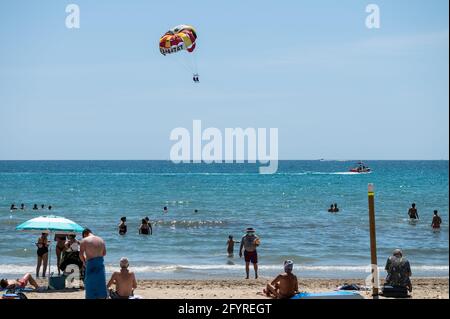 Alicante, Spanien. Mai 2021. Die Menschen genießen hohe Temperaturen am Strand El Postiguet in Alicante. Die valencianische Gemeinschaft hat am Montag neue Beschränkungsmaßnahmen gegen das Coronavirus (Covid-19) veröffentlicht, unter anderem gegen das Coronavirus, An den Stränden ist es nicht mehr notwendig, in den Ruhezeiten vor oder nach dem Baden eine Maske zu tragen und dabei den Mindestabstand von 1.5 Metern zu anderen Menschen, die nicht zusammen leben, mit einer maximalen Gruppe von 10 Personen einzuhalten. Quelle: Marcos del Mazo/Alamy Live News Stockfoto