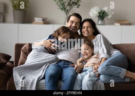 Porträt einer lächelnden multiethnischen Familie mit Kindern Entspannen Sie sich zu Hause Stockfoto