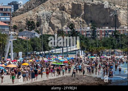 Alicante, Spanien. Mai 2021. Die Menschen genießen hohe Temperaturen in einem überfüllten El Postiguet Strand von Alicante. Die valencianische Gemeinschaft hat am Montag neue Beschränkungsmaßnahmen gegen das Coronavirus (Covid-19) veröffentlicht, unter anderem gegen das Coronavirus, An den Stränden ist es nicht mehr notwendig, in den Ruhezeiten vor oder nach dem Baden eine Maske zu tragen und dabei den Mindestabstand von 1.5 Metern zu anderen Menschen, die nicht zusammen leben, mit einer maximalen Gruppe von 10 Personen einzuhalten. Quelle: Marcos del Mazo/Alamy Live News Stockfoto