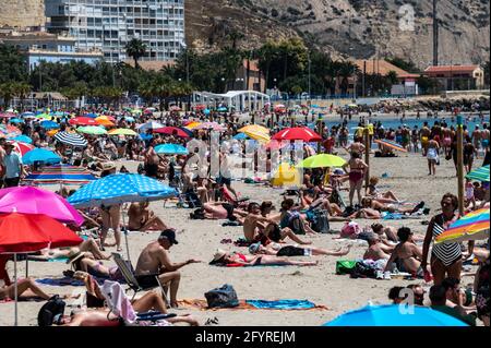 Alicante, Spanien. Mai 2021. Die Menschen genießen hohe Temperaturen in einem überfüllten El Postiguet Strand von Alicante. Die valencianische Gemeinschaft hat am Montag neue Beschränkungsmaßnahmen gegen das Coronavirus (Covid-19) veröffentlicht, unter anderem gegen das Coronavirus, An den Stränden ist es nicht mehr notwendig, in den Ruhezeiten vor oder nach dem Baden eine Maske zu tragen und dabei den Mindestabstand von 1.5 Metern zu anderen Menschen, die nicht zusammen leben, mit einer maximalen Gruppe von 10 Personen einzuhalten. Quelle: Marcos del Mazo/Alamy Live News Stockfoto