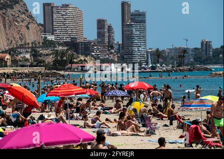 Alicante, Spanien. Mai 2021. Die Menschen genießen hohe Temperaturen in einem überfüllten El Postiguet Strand von Alicante. Die valencianische Gemeinschaft hat am Montag neue Beschränkungsmaßnahmen gegen das Coronavirus (Covid-19) veröffentlicht, unter anderem gegen das Coronavirus, An den Stränden ist es nicht mehr notwendig, in den Ruhezeiten vor oder nach dem Baden eine Maske zu tragen und dabei den Mindestabstand von 1.5 Metern zu anderen Menschen, die nicht zusammen leben, mit einer maximalen Gruppe von 10 Personen einzuhalten. Quelle: Marcos del Mazo/Alamy Live News Stockfoto