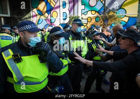 Manchester, Großbritannien. Mai 2021. Die Polizei hält Demonstranten davon ab, während eines Protestes gegen die Sperre das Einkaufszentrum Westfield zu stürmen. Die Zahl der Teilnehmer an den Protesten ist seit Einführung der COVID-19-Beschränkungen von Monat zu Monat gestiegen. Kredit: Andy Barton/Alamy Live Nachrichten Stockfoto