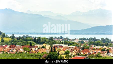 Landschaft mit Bodensee oder Bodensee, Bayern, Deutschland. Panorama der kleinen Stadt mit Blick auf die Schweizer Alpen im Sommer. Landschaftlich schöner Blick auf das deutsche Dorf an Stockfoto