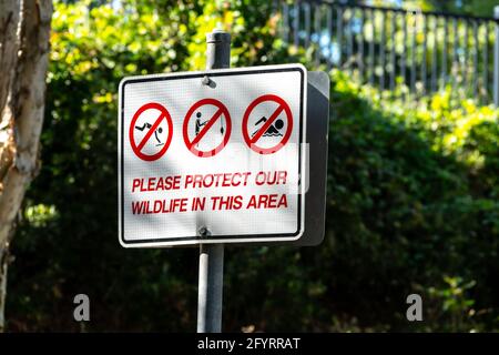 Schild mit Aktivitäten, die zum Schutz der Tierwelt in einem Park in Queensland, Australien, verboten sind - kein Schwimmen, kein Angeln, kein Tauchen Stockfoto