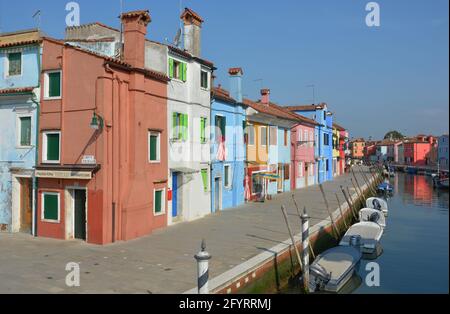 BURANO, VENEDIG, ITALIEN - 20. Jun 2019: Eine Reihe von bunten Häusern und Geschäften an einem Kanal in Burano, Venedig, Italien. Stockfoto