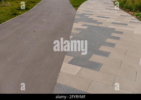 Fliesen und Asphalt Kombination im Hof. Im Hof treffen sich zwei Wege aus verschiedenen Materialien. Stockfoto