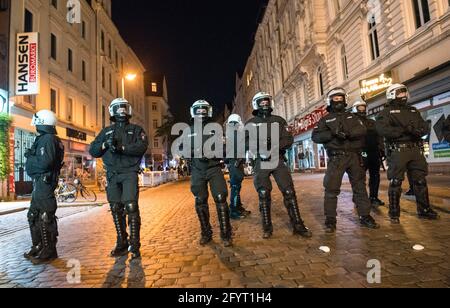 Hamburg, Deutschland. Mai 2021. Polizeibeamte mit Helmen blockieren den Eingang zum Schanzenviertel spät am Abend. Nachdem sich zahlreiche Menschen in Parks und auf den Straßen versammelt hatten, hat die Polizei das Viertel am Abend geräumt und stattdessen Geschäfte und Gastronomie schließen lassen. Quelle: Daniel Bockwoldt/dpa/Alamy Live News Stockfoto