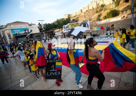 Malaga, Spanien. Mai 2021. Kolumbianische Demonstranten werden in einer Schlange tanzen sehen, während sie an einem Protest auf der Alcazabilla Straße teilnehmen.nach einem Monat der Proteste nach dem sozialen Ausbruch in Kolumbien, Dutzende von Kolumbianern, die in Malaga leben, zeigen erneut ihre Solidarität mit der kolumbianischen Bevölkerung und gegen die Gewalt der Regierung von Präsident Iván Duque. Kredit: SOPA Images Limited/Alamy Live Nachrichten Stockfoto