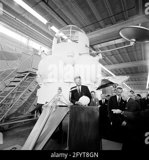 12. September 1962Präsident John F. Kennedy (auf dem Rednerpult) gibt nach einer Führung durch Raumfahrzeuge in einem Hangar im Rich Building des bemannten Raumschiffszentrums, Houston, Texas, eine Rede ab. Präsident Kennedy hält ein maßstabsgetreues Modell des Apollo-Kommandomoduls, das ihm der Direktor des bemannten Raumschiffszentrums, Dr. Robert Gilruth, präsentiert hat; im Hintergrund sitzt ein Modell des Mondlanders (auch bekannt als „der Bug“). Im Hintergrund: Administrator der National Aeronautics and Space Administration (NASA), Dr. James E. Webb; Gouverneur von Texas, Price Daniel; Director of Operations für PR Stockfoto