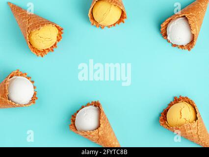 Weiße und gelbe Eiszapfen auf hellblauem Hintergrund. TFlat Lay, Kopierbereich. Stockfoto