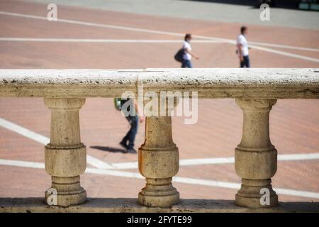 Arezzo, Italien, 28. Mai 2021, antike Steinsäulen einer Balustrade und im unscharfen Hintergrund Menschen, die auf dem Platz spazieren Stockfoto