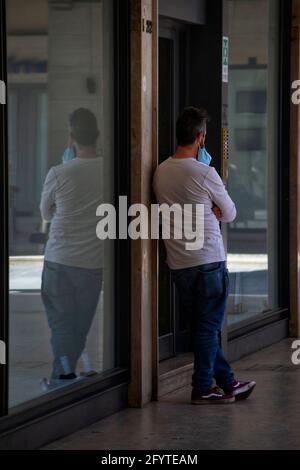 Arezzo, Italien, 28. Mai 2021, ein junger Mann, der vor einem Geschäft steht Stockfoto