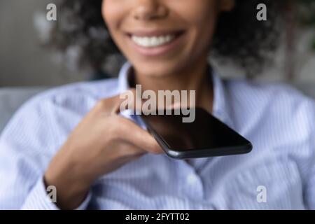 Nahaufnahme einer Birazialfrau, die über Lautsprecher auf dem Mobiltelefon spricht Stockfoto