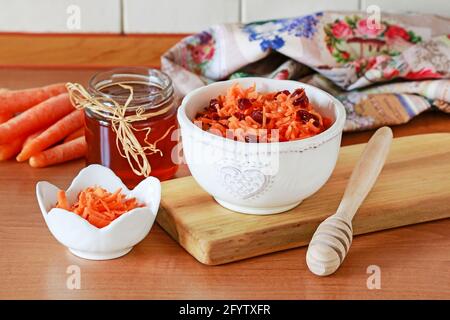 Karotten- und Preiselbeersalat in Keramikschüssel. Gesunde Ernährung Stockfoto