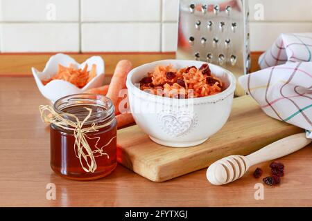 Karotten- und Preiselbeersalat in Keramikschüssel. Gesunde Ernährung Stockfoto