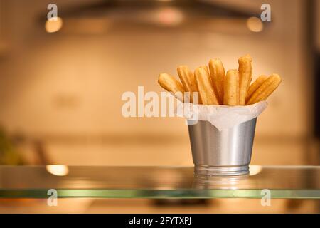 Churros klebt hausgemachte süße Backwaren mit Zucker und Zimt auf einem Küchenhintergrund in Unschärfe. Stockfoto