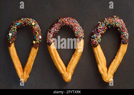 Churros traditionelles spanisches Fast Food mit Gebäck auf dunklem Hintergrund. Draufsicht Stockfoto