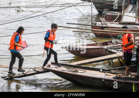 (210530) -- GUIPING, 30. Mai 2021 (Xinhua) -- Yuan Ting (2. L) und Kollegen besteigen ein Fischerboot, um im Wasserschutzgebiet der Datengxia-Schlucht in Guiping, der autonomen Region Guangxi Zhuang, im Süden Chinas, Forschung über Fischereiressourcen durchzuführen, 29. Mai 2021. Dr. Yuan Ting, Experte für ökosystembasierte Fischerei und Zucht seltener Fischarten, kam 2020 mit einem Team von Forschern in die Wasserschutzzone der Dateng-Schlucht. Der Schwerpunkt ihrer Forschung liegt auf der Rettung, dem Schutz und der Zucht seltener Fischarten, die im Pearl River-Becken beheimatet sind. Am 28. Mai gab Yuan's Team 100,000 Fischbraten frei, die sie hatten Stockfoto