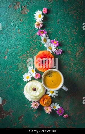 Tasse Kaffee mit Blumenvariation auf grünem Hintergrund Mit Kopierbereich Stockfoto