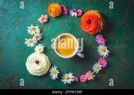 Tasse Kaffee mit Blumenvariation auf grünem Hintergrund Mit Kopierbereich Stockfoto