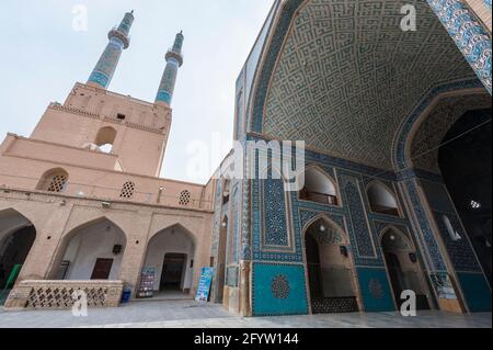 Innen mit schönen Kacheln und Rückseite des Portals mit zwei Minaretten der Jameh-Moschee in Yazd, Provinz Yazd, Iran. Stockfoto