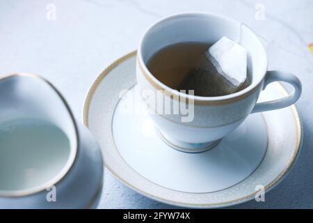 Grüner Tee mit Teebeutel auf Fliesen Hintergrund Stockfoto