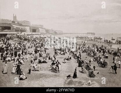 Ein Blick aus dem späten 19. Jahrhundert auf Besucher, die den Strand von Ramsgate, einer Küstenstadt im Stadtteil Thanet im Osten von Kent, England, genießen. Der Official Illustrated Guide to South-Eastern and North and Mid-Kent Railways (Juni 1863) beschreibt Ramsgate folgendermaßen: „Es ist unmöglich, zu positiv über diese erstklassige Stadt, ihren herrlichen Sand, ihr Baden, ihre Hotels, Bibliotheken, Kirchen, etc. Etc. Nicht zu vergessen das belebende Klima ... die Straßen von Ramsgate sind gut gepflastert oder makadamed und brillant mit Gas beleuchtet." Stockfoto