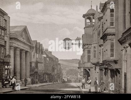 Eine Ansicht der High Street aus dem späten 19. Jahrhundert in Guildford, Surrey, England, mit der markanten Uhr und dem turrettierten Glockenturm, der Guildhall, dem ehemaligen Rathaus und dem Gerichtssaal. Die Guildhall wurde 1683 mit der Uhr besetzt. Die Uhr wurde angeblich von John Aylward, einem Londoner Uhrmacher, der in der Stadt Geschäfte machen wollte, an die Stadt übergeben. Stockfoto