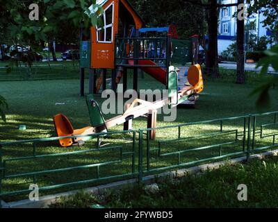 Kinderspielplatz unter den Bäumen am Morgen, im Sommer Stockfoto