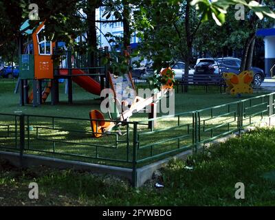 Kinderspielplatz unter den Bäumen am Morgen, im Sommer Stockfoto