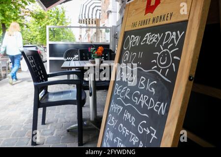 (210530) -- BRÜSSEL, 30. Mai 2021 (Xinhua) -- EIN Fußgänger passiert die Werbetafel der Bar 'Funky Monkey', in Brüssel, Belgien, 28. Mai 2021. Für Barmanager Luke Nolan kam die Entscheidung der belgischen Regierung, dem Gastgewerbe ab Mai 8 die Freiluftterrasse wieder zu eröffnen, nicht zu früh. Zuvor überlebten Luke und seine Kollegen Monate der harten Handhabung der Bar aufgrund der COVID-19-Pandemie und erspiesten abends Mahlzeiten zum Mitnehmen. „Es war eine große Erleichterung für alle und ausgezeichnet für uns, wieder am Arbeitsplatz zu sein und hervorragend für unsere psychische Gesundheit. Für Stockfoto