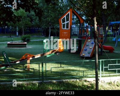 Kinderspielplatz unter den Bäumen am Morgen, im Sommer Stockfoto