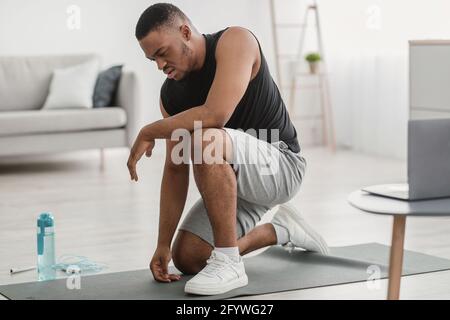 African Fitness Guy Gefühl Schlecht Während Online-Training Zu Hause Stockfoto