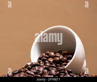 Kaffeebohnen in einer weißen Keramikschale. Konzept für Essen und Trinken, entspannende Zeit, Wellness Stockfoto