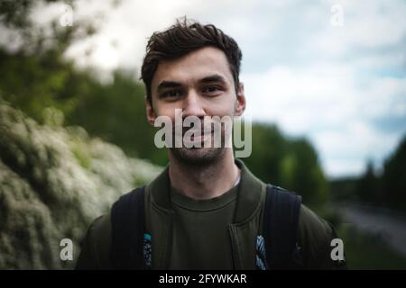 Ein flacher Fokus eines lächelnden, gut aussehenden jungen bärtigen Ukrainerin Wanderer, männlich Stockfoto