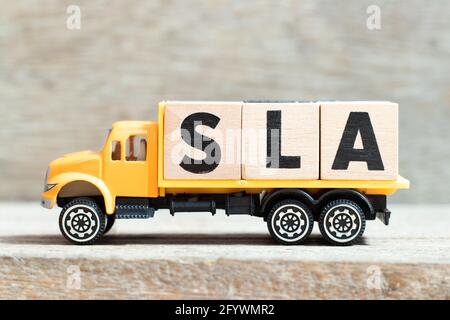 Spielzeug LKW halten Alphabet Buchstaben Block in Wort SLA (Abkürzung für Service Level Agreement) auf Holzhintergrund Stockfoto